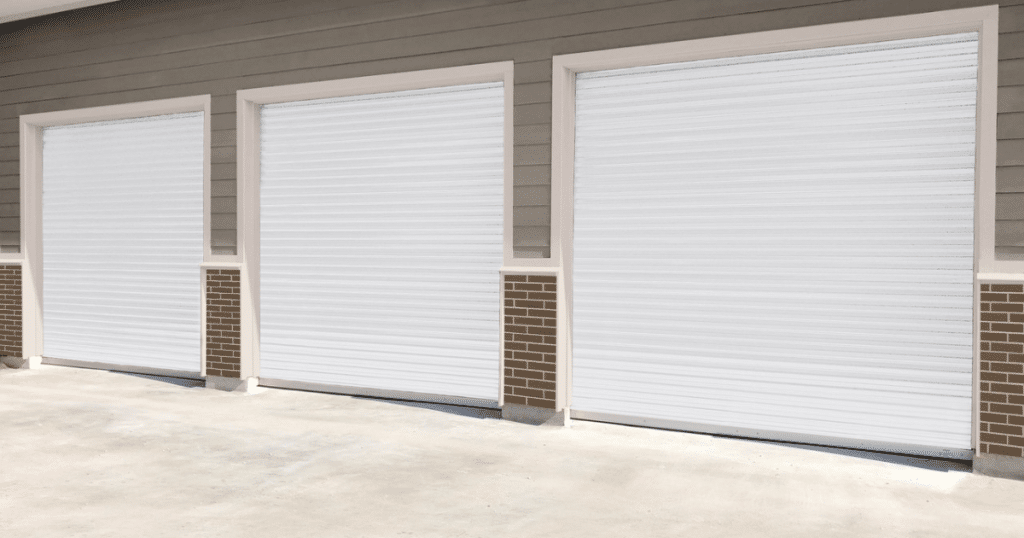 Three white rolling garage doors closed tight