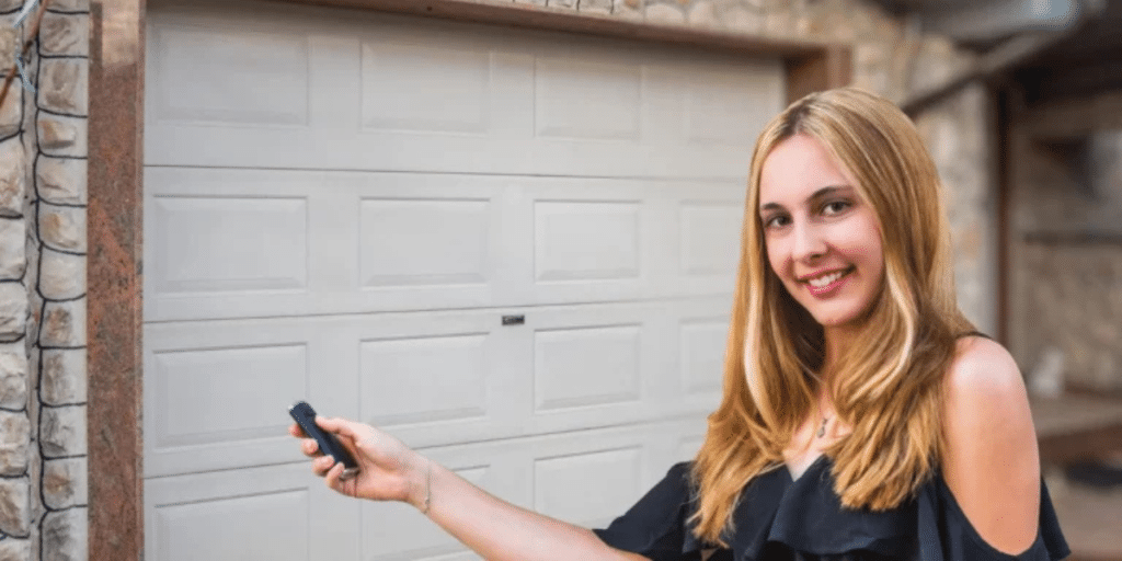 Smiling woman opens garage with remote.